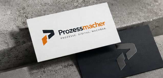 Prozessmacher-Visitenkarten auf einem strukturierten Betontisch